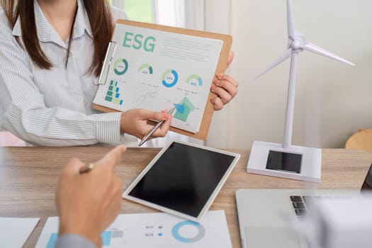 A business meeting focused on ESG data analysis and renewable energy models, showcasing innovative strategies for sustainability.