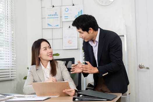 A businesswoman and businessman collaborate on financial strategies, showcasing teamwork and effective communication.