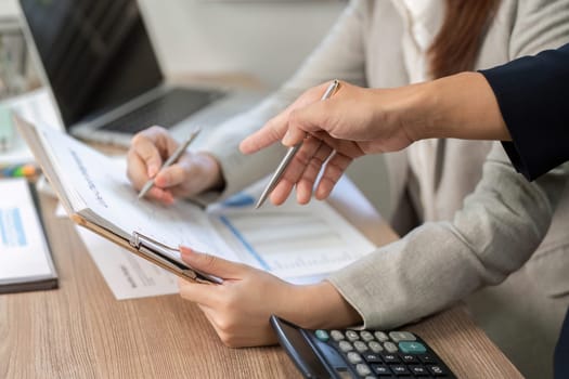 Close-up of hands reviewing financial documents during a collaborative planning session, emphasizing teamwork and strategy.