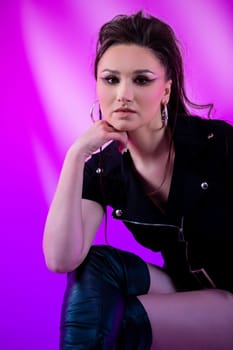 A strikingly beautiful model in the realm of contemporary fashion elegantly posing against a colorful, vibrant backdrop
