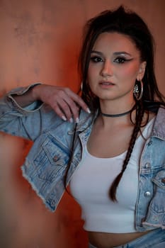 A young woman poses confidently in stylish denim, showcasing her fashionable accessories and vibrant expression