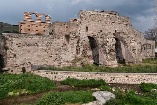 Red Basilica, aka Kizil Avlu, ancient ruins by a river in Bergama, Turkey. Historical landmark under cloudy sky