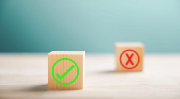 Wooden block featuring green check mark and red x. Conceptualizes choice and decision making. Think With Yes Or No Choice.