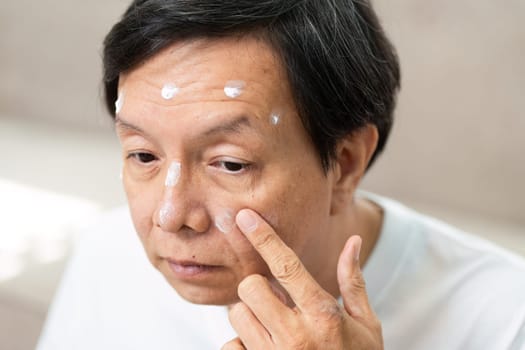 The man is focusing on applying skincare products to specific areas of his face, emphasizing a detailed skincare routine for optimal results.