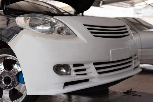 Denter or car mechanic serviceman check and fix body work and fiber bumper body part for fix and repair problem at car garage or repair shop