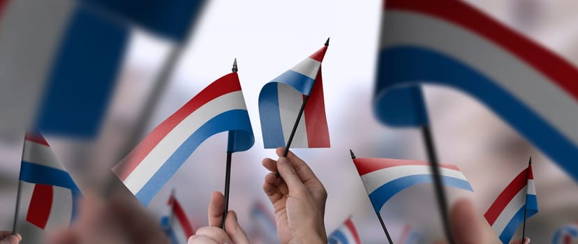 Netherlands flags in their hands on a blurred urban background. The photo illustration was created without the use of artificial intelligence, only using Photoshop.