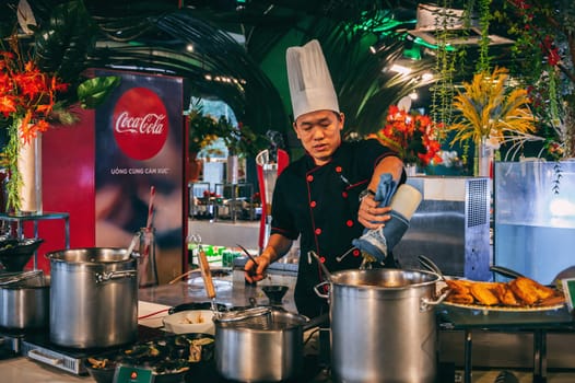 A Vietnamese chef cooks in the Asian buffet hall. Nha Trang, Vietnam - December 12, 2024