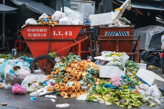 Piles of plastic bags, cardboard boxes and organic waste next to overflowing dumpsters. . Nha Trang, Vietnam - December 13, 2024
