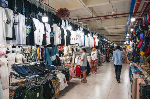 A lively passage of an indoor clothing market with clothing items on display. Nha Trang, Vietnam - December 13, 2024
