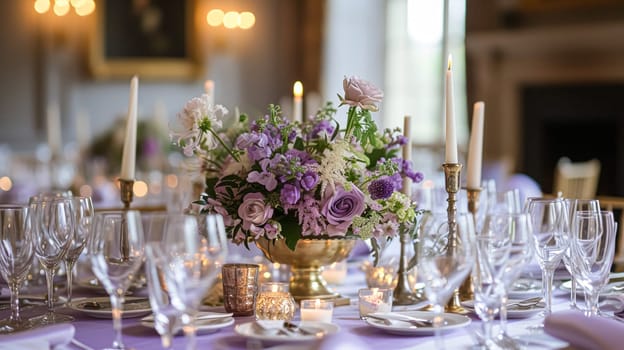 Elegant indoor wedding dining table with floral arrangements in shades of purple, lavender and pink, set in a grand room with mirrors and chandeliers.