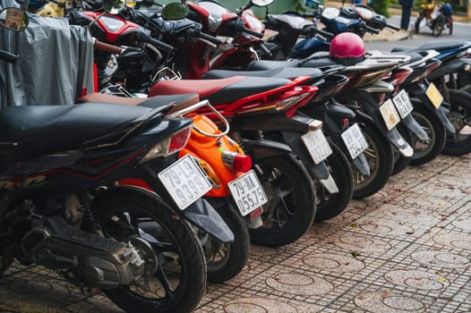 A number of parked bikes are available for rent in the parking lot. Nha Trang, Vietnam - December 16, 2024
