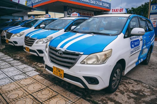 Several parked Asian taxi cars lined up in the parking lot on the street. Nha Trang, Vietnam - December 16, 2024
