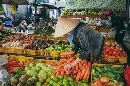 A Vietnamese woman buys fresh vegetables at a local Nha Trang market, Vietnam - December 16, 2024