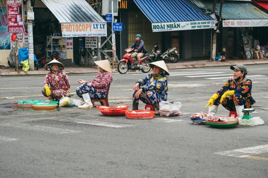 Vietnamese women sell fresh fish and seafood on the road. Nha Trang, Vietnam - December 16, 2024