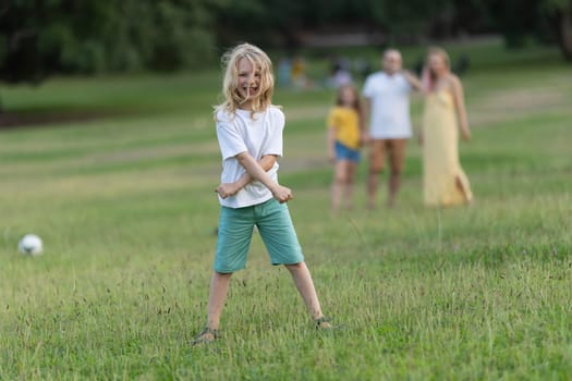 Child having fun with his family in a green park during a summer afternoon
