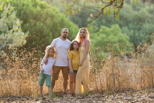 Family with two daughters posing together in a nature reserve