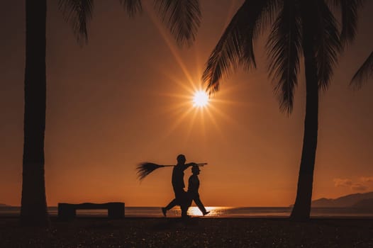 Silhouette of male janitors on the waterfront in Vietnam at dawn in the morning