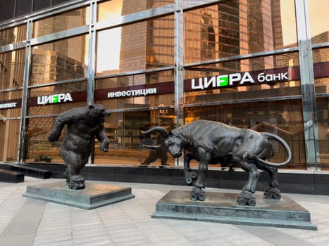 Moscow, Russia, April 26, 2025: Modern sculptures of bear and bull on roller skates in front of CIFRA Bank in Moscow City highlight the dynamic nature of financial markets and investment behavior