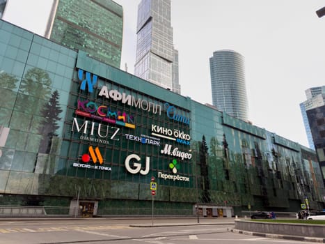 Moscow, Russia, April 26, 2025: Exterior view of the Afimall City shopping center in Moscow City with bright brand logos including Vkusno i Tochka, M Video, Technopark and others