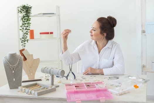 Professional jewelry designer making handmade jewelry in studio workshop. Fashion, creativity and handmade concept.