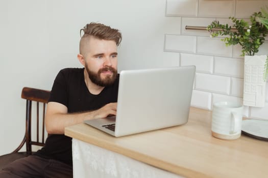 Smiling man working with laptop at home. Technology, home and lockdown concept.