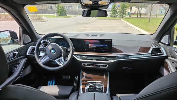Ottawa, ON Canada - 04.22.2023: Luxurious BMW X5 Vehicle Interior Displaying Advanced Technology and Elegant Wood Trim Design Elements.