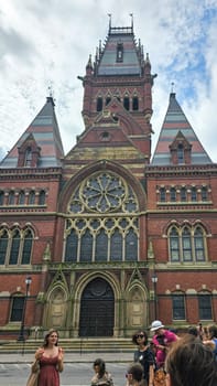 Boston, MA USA - 08.04.2024: Historic Harvard University Building Facade with Ornate Architectural Detail and Tourists below.