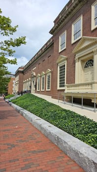 Boston, MA USA - 08.04.2024: Historical Brick Building Facade with Ivy Covered Hill in Urban Setting, New England Area.