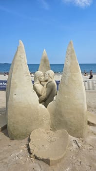 Boston, MA USA - 08.05.2024: Romantic Sand Sculpture of a Couple Kissing on a Beach, Artistic Sandcastle at Seaside.