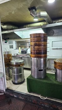 Bishkek, Kyrgyzstan - 10.05.2024: Traditional Bamboo Steamer Stacks in Asian Restaurant Kitchen, Culinary Preparation Area.