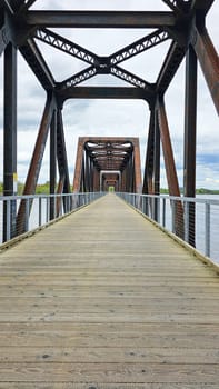 Ottawa, ON Canada - 05.14.2025: Scenic Walkway Perspective View of a Metal Truss Bridge with Wooden Path. Travel Destination