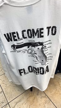 Miami, FL USA - 12.24.2025: Humorous Florida Welcome T-Shirt Displaying a Gun with City Names, Tourist Souvenir.