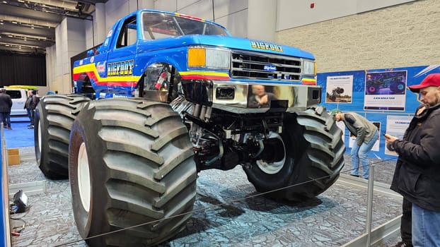 Toronto, ON Canada - 02.16.2025: Spectacular Monster Truck Display at Automotive Show, Huge Tires and Powerful Engine, Blue Body.