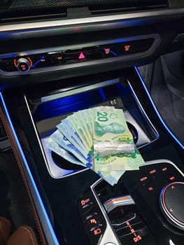 A luxurious car interior featuring plush leather seats and elegant finishes, paired with a stylish collection of banknotes, symbolizing financial readiness for exciting journeys and opportunities.