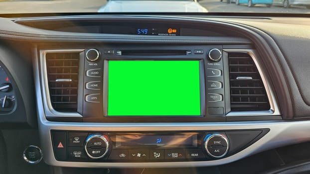 Close-up of a car dashboard showcasing a vibrant green screen display, perfect for automotive technology mockups and advertising. Interior view of modern vehicle, ready for text or image placement.