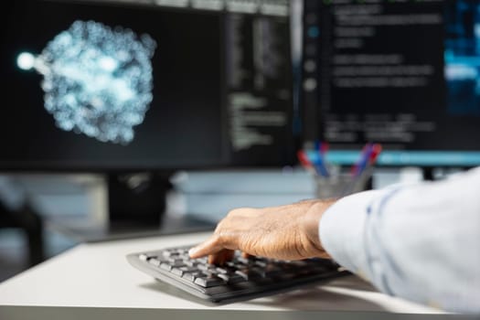 Close up of data center engineer using artificial intelligence visualization tools on PC to identify equipment malfunctions. Server room expert typing on keyboard, looking at AI generated insights