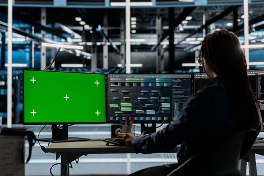 Server room technician using artificial intelligence tech on green screen PC to reduce downtime. Admin using chroma key computer to design and implement AI driven solutions for data center equipment