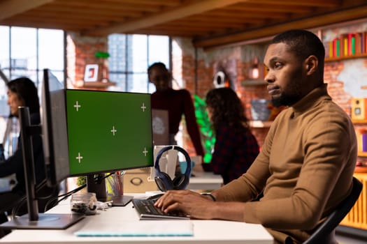 Startup entrepreneur using green screen PC to do research, looking to grow value of company. African american venture business manager using mockup computer, building innovative growth strategy
