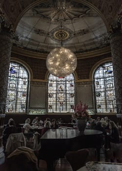 London, UK - May 07, 2025 - People and tourists enjoying meeting and afternoon tea inside of The Gamble Room inside The V&A (Victoria and Albert Museum) in London. The magnificent interior view of the world's oldest museum restaurant, use it as your Wallpaper, Poster and Space for text, Selective focus.