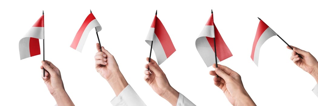The Indonesia flag in hand in different angles on a white background.