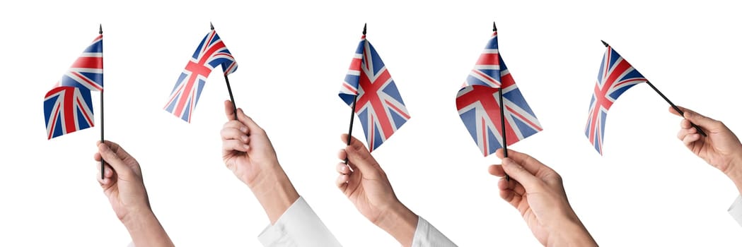 The United Kingdom flag in hand in different angles on a white background.