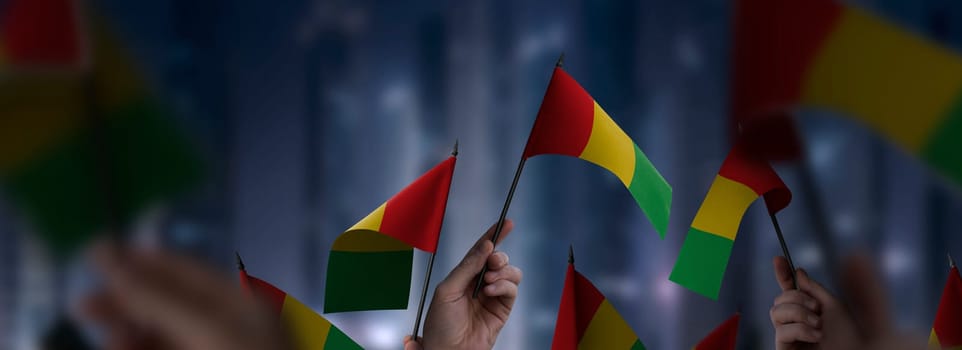 Guinea flags in their hands on a blurred urban background. The photo illustration was created without the use of artificial intelligence, only using Photoshop.