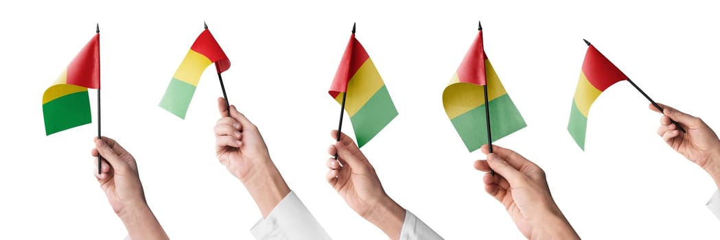The Guinea flag in hand in different angles on a white background.