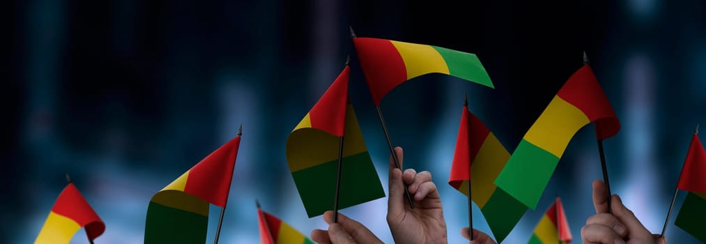 Guinea flags in their hands on a blurred urban background. The photo illustration was created without the use of artificial intelligence, only using Photoshop.
