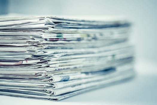 Pile of newspapers on table. Folded and stacked journals.