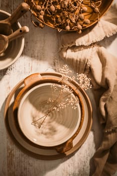 Set of ceramic tableware. Empty craft ceramic plates, bowls and cups kitchen table