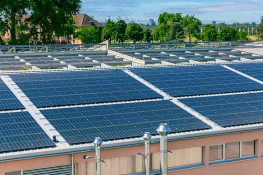 Solar panels installed on a roof of a large industrial building or a warehouse.