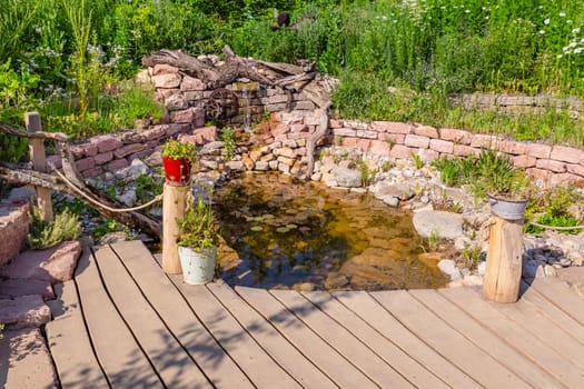Natural garden with small patio, native plants, natural stones, pond and potted plants