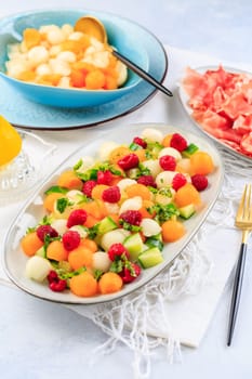 Summer light food. Cucumber and melon salad with raspberries and Prosciutto and pickled hot peppers