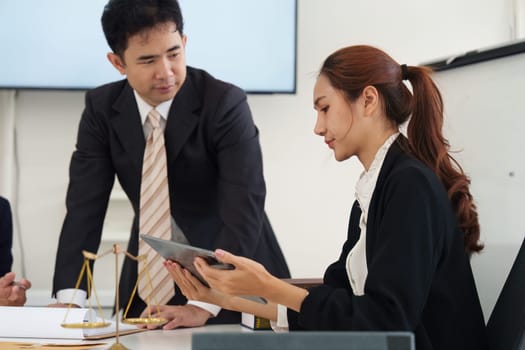 A lawyer provides guidance to a client while reviewing digital documents, emphasizing collaboration and strategic planning in legal scenarios.